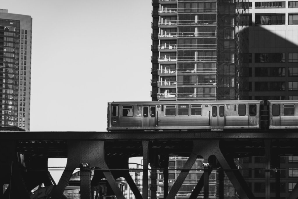 Black and white image of urban train and skyscrapers in Chicago.